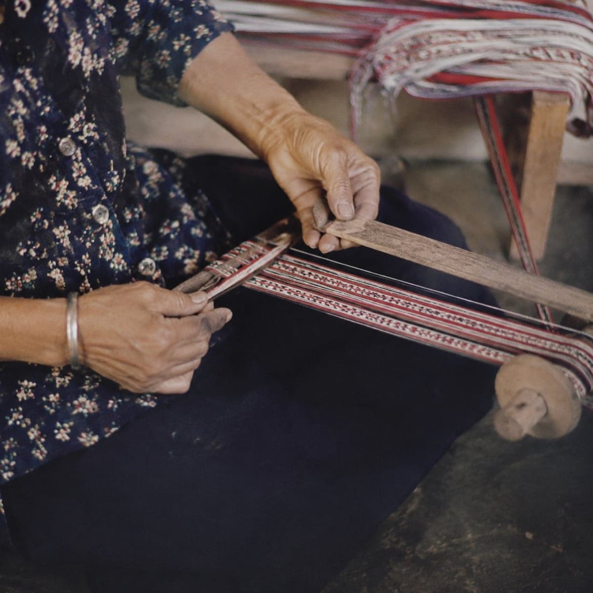 Founder's hands at a traditional webbing loom